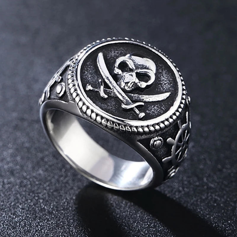 Bague Pirate Vintage Chevalière Tête de Mort, Double Sabres croisés et Barres de gouvernail sur les côtés en Acier Inoxydable Argenté posée face haut - Trésors de Pirate