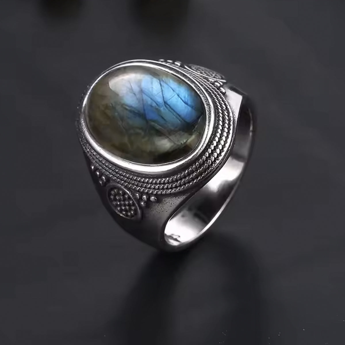 Bague Pirate en Argent et sertie de Labradorite ovale posée face et côté gauche sur fond gris